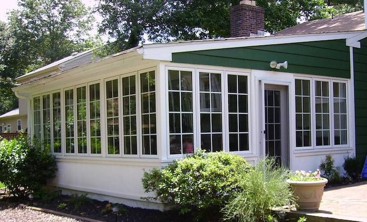 Porch enclosed with casement windows with grids.