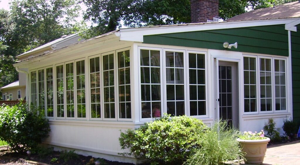 Green house. Sunroom with white white casement windows with grids.