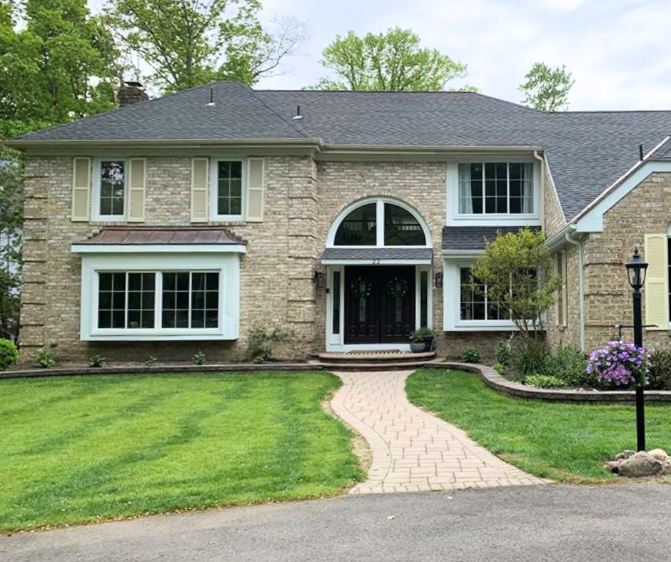 Large, brick home featuring box bay window with Slider Windows and Quarter Round Architectural Shaped Windows in White. Paved walkway.