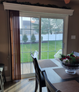 Interior view of dining room sliding patio door with vertical blinds.